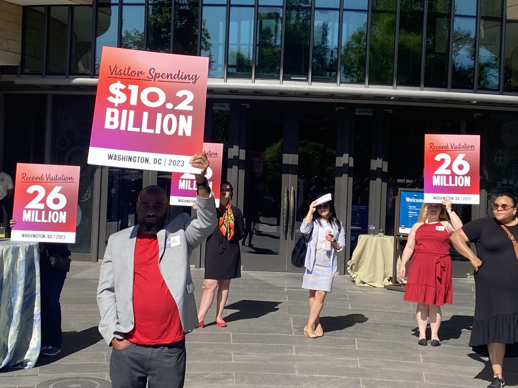 dc tourism announcement people carrying signs showing recordbreaking numbers