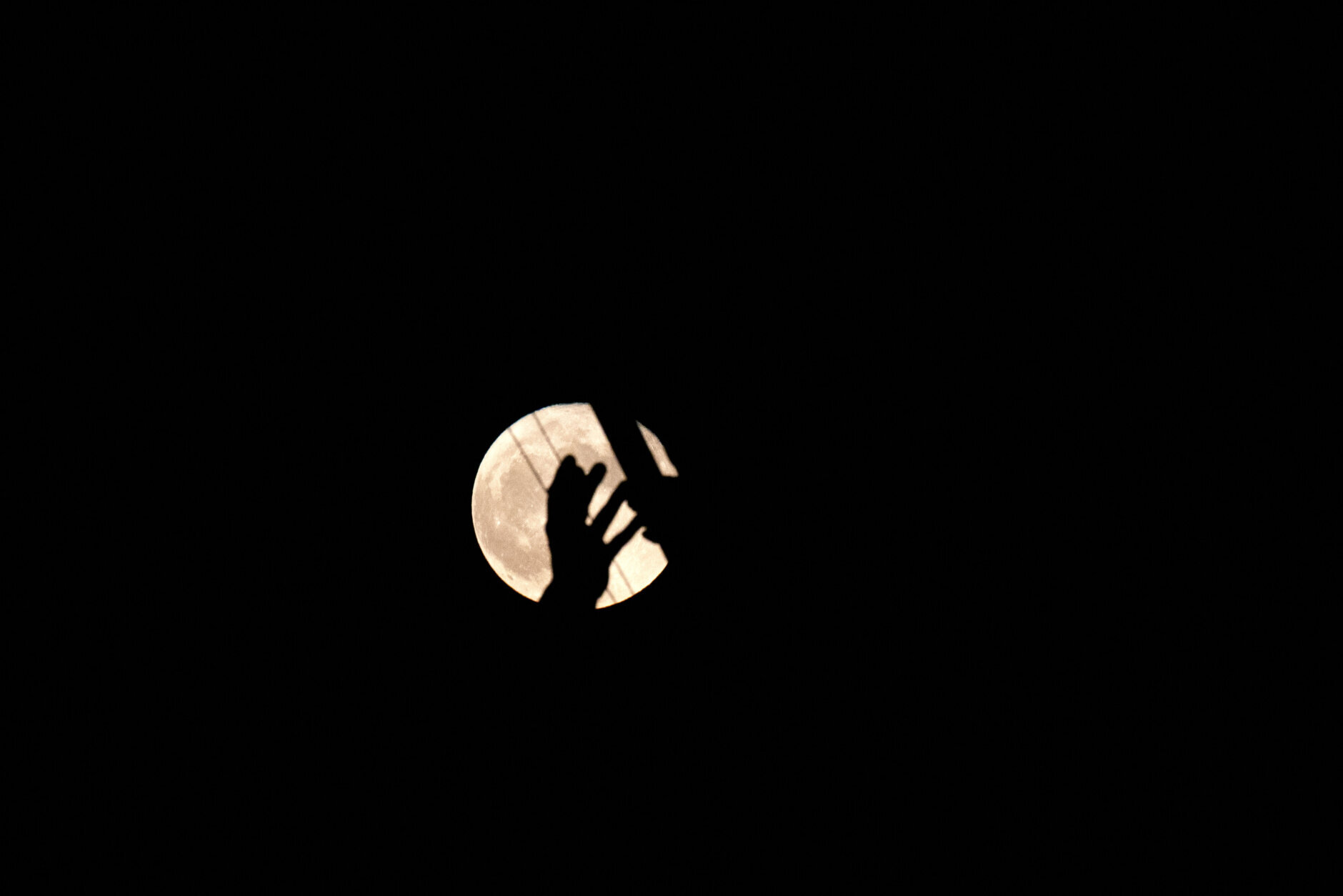 The full "Strawberry moon" is seen past the US Marine Corps War Memorial in Arlington, Virginia, on June 14, 2022. (Photo by Stefani Reynolds/AFP via Getty Images)