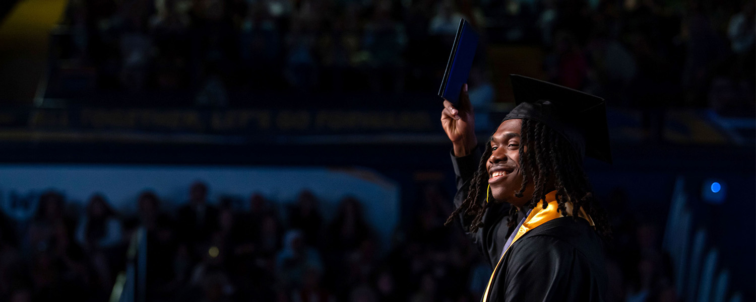 Anthony Claytor raises his diploma during his Commencement ceremony at Kent State University.