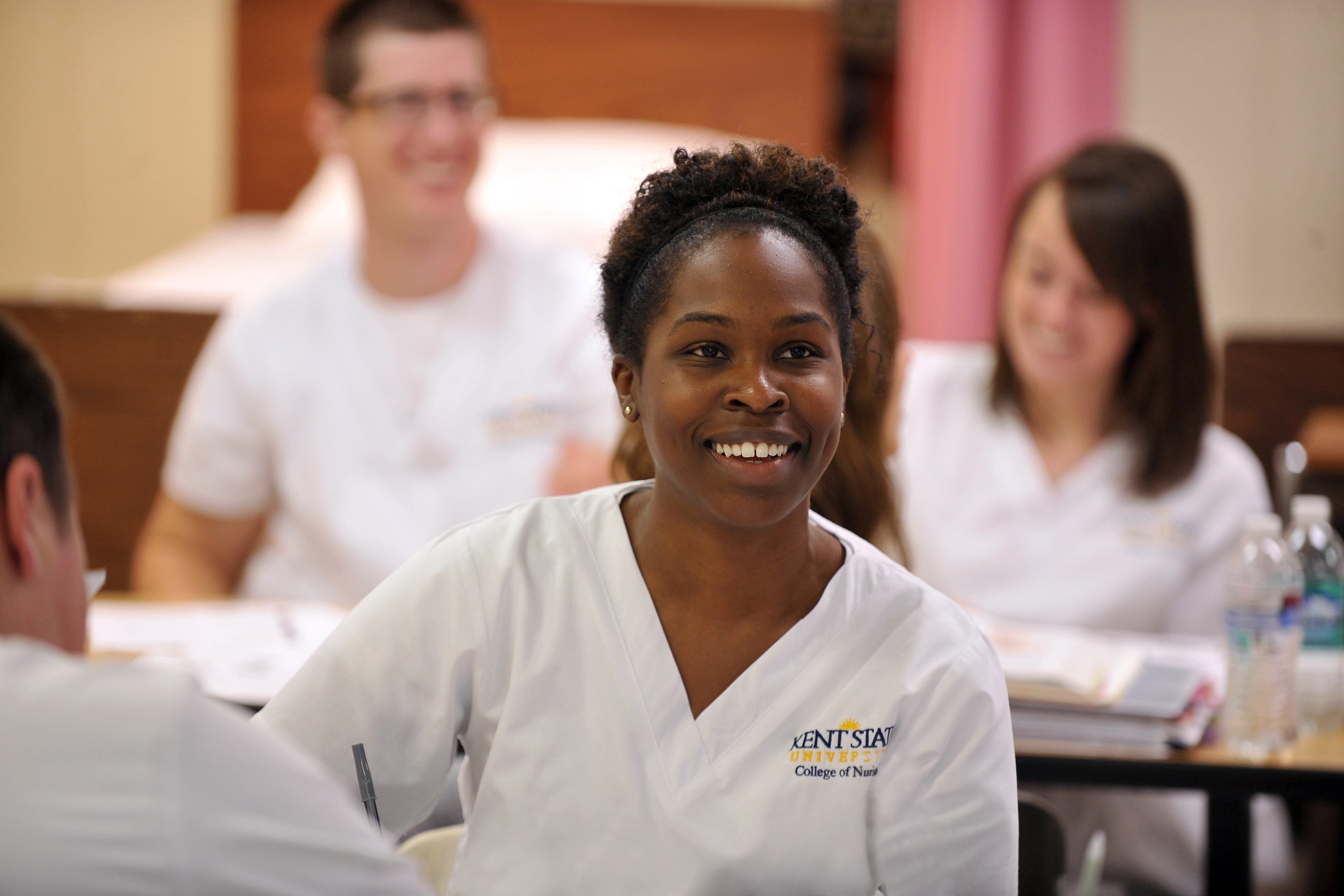 A smiling nursing student looks on during a nursing class. 