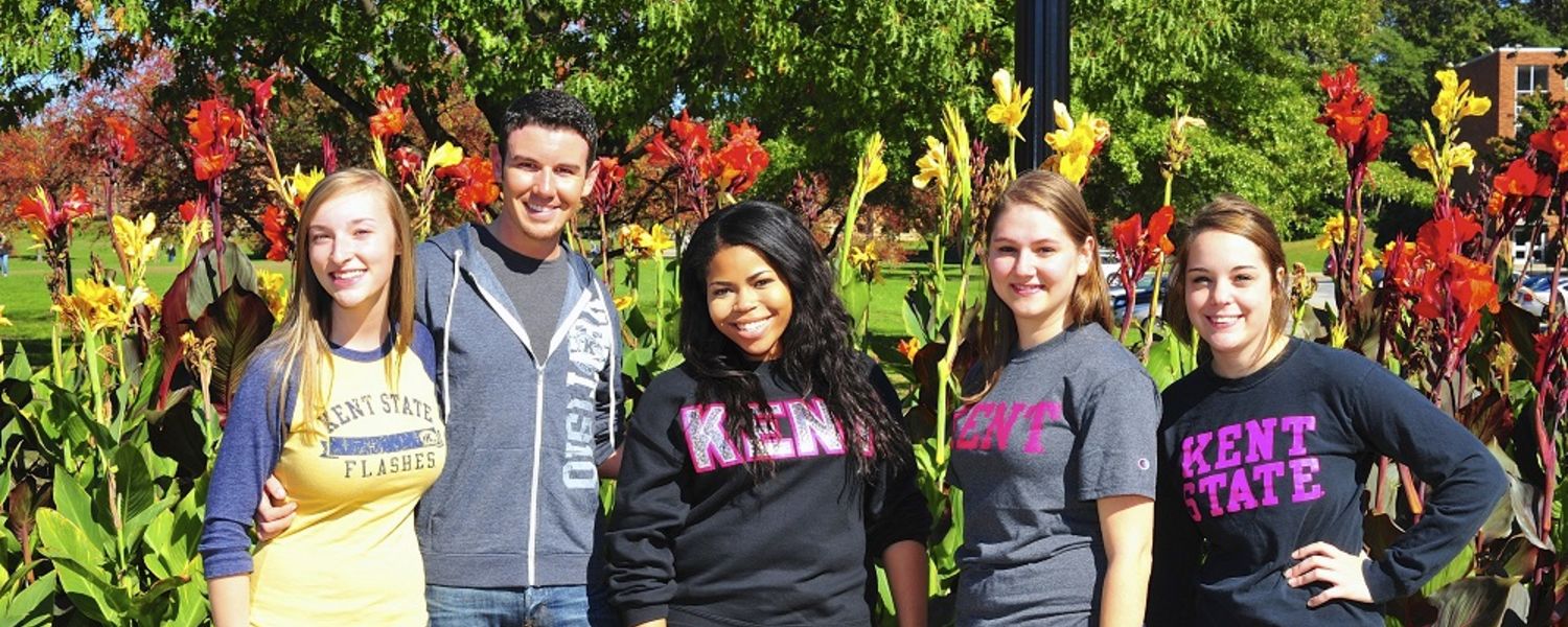 A group of students take a photo in the flower garden on campus.