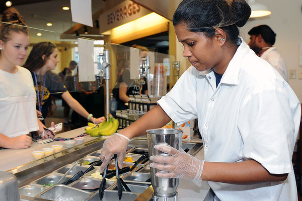 A food service employee mixes a smoothie for a student in the exclusively gluten free Prentice Hall Café.