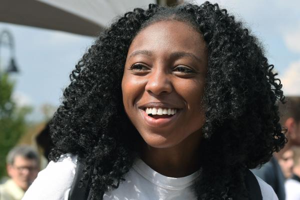 A female student looks on and smiles during an event at Risman Plaza near the Kent Student Center.