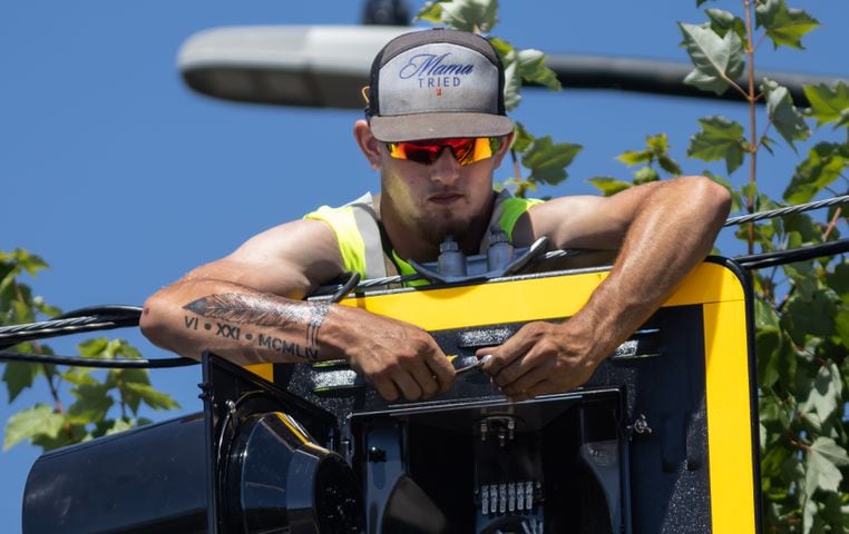 Blake Hales with Reedwick LLC installed traffic signal lights in the heat at Memorial Drive and Martin Street SE in Atlanta dealing with temperatures close to record highs on Tuesday, June 25, 2024. The highest temperature recorded on June 25 was 99 degrees set in 1988. Tuesday, the city was expected to top out around 97 degrees. The average is 88 degrees. (John Spink/AJC)