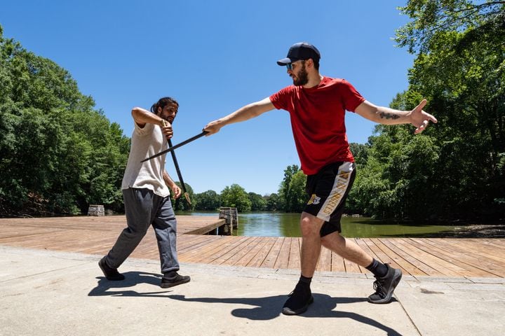Stunt actors (from left) Brandon Martinez and Nathan Kayn practice sword fighting at Piedmont Park in Atlanta on Tuesday, June 25, 2024. (Seeger Gray / AJC)
