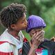 The victim's friend, Carnelo Brittain (left), and mother Stardrecous Brooks hug each other after the deadly shooting.