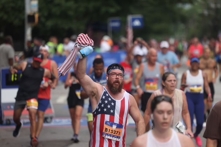 Runners celebrate at the finish of the 55th running of the Atlanta Journal-Constitution Peachtree Road Race in Atlanta on Thursday, July 4, 2024.   (Jason Getz / AJC)