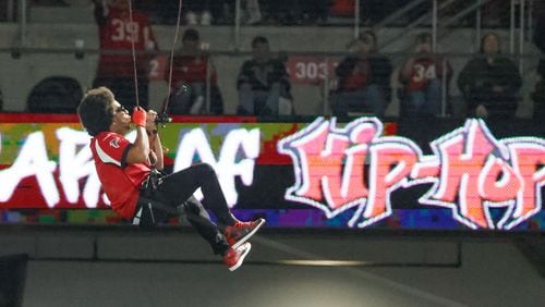 Ludacris descends from the top of the stadium while performing during the game.  The Atlanta Falcons celebrate Hip-Hop 50 with performances and appearances during their NFL football game between the Atlanta Falcons and the New Orleans Saints in Atlanta on Sunday, Nov. 26, 2023.   (Bob Andres for the Atlanta Journal Constitution)