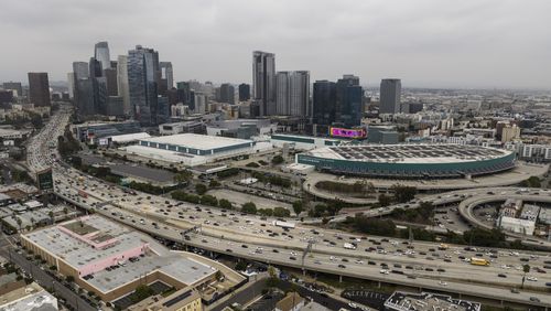 FILE - This aerial view shows traffic moving along the 110 Freeway past the Los Angeles Convention Center in Los Angeles, Tuesday, Sept. 5, 2023. As the Olympics close in Paris, Los Angeles will take the torch. The city will become the third city to host the games three times as it adds 2028 to the locally legendary years of 1932 and 1984. (AP Photo/Jae C. Hong, File)