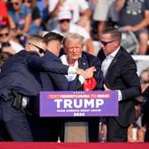 Republican presidential candidate former President Donald Trump is helped off the stage at a campaign event in Butler, Pa., on Saturday, July 13, 2024. (AP Photo/Gene J. Puskar)