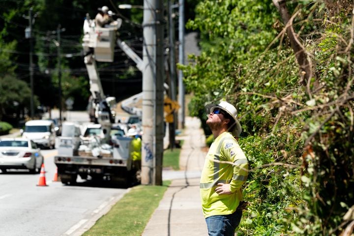A Fairway Electric Inc. worker watches maintenance work on a telephone pole in Atlanta on Monday, June 24, 2024. (Seeger Gray / AJC)