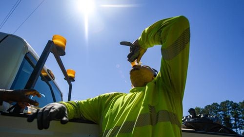 Anthony Lowe, staff of the city of Fayetteville public works, takes a water break on the side of a highway in Fayetteville on Tuesday, June 25, 2024.  (Ziyu Julian Zhu / AJC)