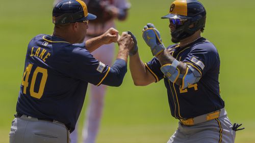 Milwaukee Brewers' William Contreras, right, high-fives third base coach Jason Lane after hitting a two-run home run during the first inning of a baseball game against the Atlanta Braves, Thursday, Aug. 8, 2024, in Atlanta. (AP Photo/Jason Allen)