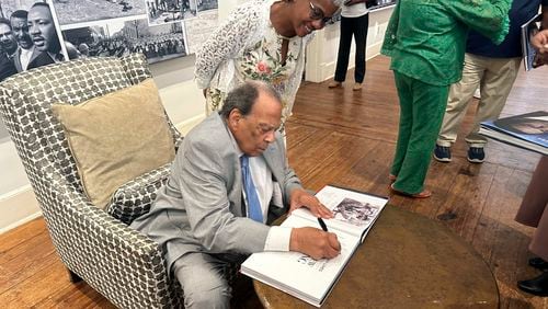 Civil rights icon Andrew Young signs a book for Sonjia Daymond at the opening of a traveling exhibit chronicling his life, Thursday, Aug. 8, 2024 in Thomasville, Ga. (AP Photo/Brendan Farrington)