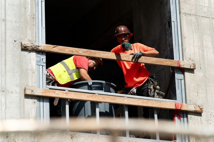 Workers look out from a window at a construction site in Atlanta on Monday, June 24, 2024. (Seeger Gray / AJC)