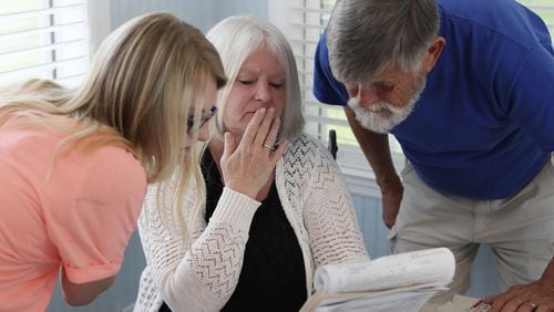 Kim Ross, with her husband and daughter in June, views a regulatory report filed on incidents at Rosewood Assisted Living. She thinks her mother, Iris Carter, was abused at the Fort Oglethorpe facility, which reported that Carter fell. DCH cited the home for failing to provide protective care and watchful oversight for three residents, including Carter. (BOB ANDRES / BANDRES@AJC.COM)