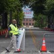 Captain A. Hill with the Georgia Tech Police moves signage into place along Fowler Street and 6th Street as roads closed early Thursday morning, June 27, 2024 near CNN Studios on the Techwood campus in Midtown ahead of Thursday night’s debate between President Joe Biden and former President Donald Trump. (John Spink/AJC)