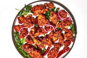 overhead view of indian spiced chicken 65 on round plate with peppers