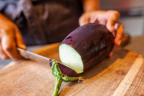 slicing eggplant on a cutting board