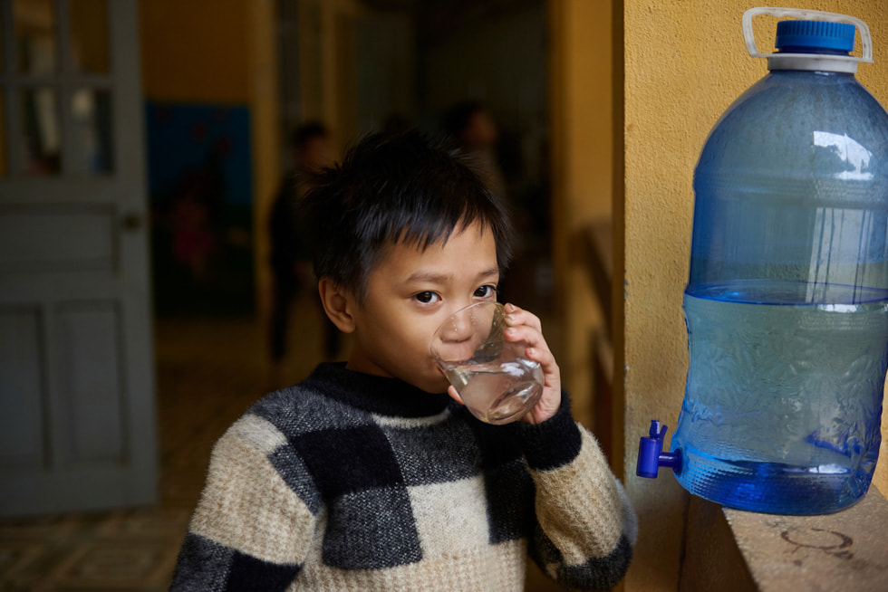 Seorang siswa tampak sedang meminum air yang dihasilkan dari sistem Gravity Water di Sekolah Dasar dan Menengah Berasrama untuk Etnis Minoritas Vay Nua
