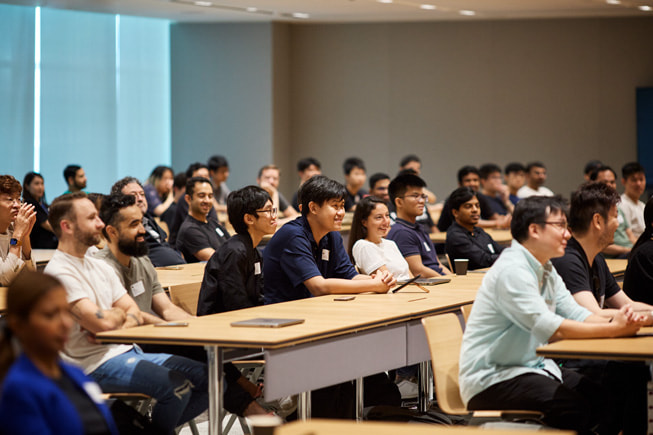 A group of developers sitting in an Apple Developer Center is shown.