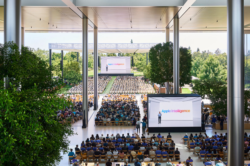 Apple Park’ta Caffè Macs’teki büyük ekranlarda Keynote sunumunu izleyen geliştiricilerin üstten çekilmiş görüntüsü. 