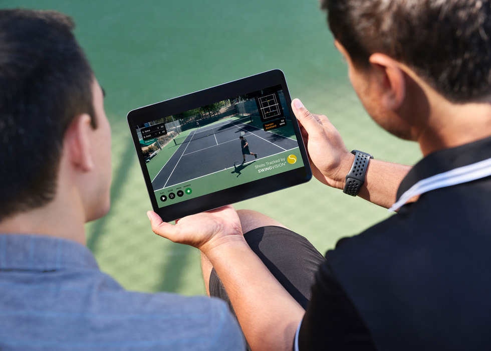 Sahai holds iPad that shows recorded match footage as he and his opponent watch.