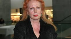 A white woman with auburn hair in a black shirt.