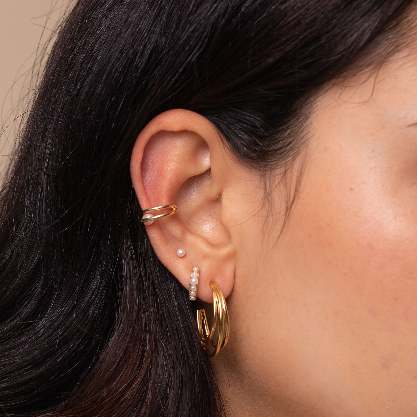 Radiant Pearl Huggies in Gold worn with other earrings