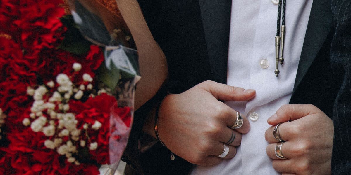 a transmasc in a suit and flowers