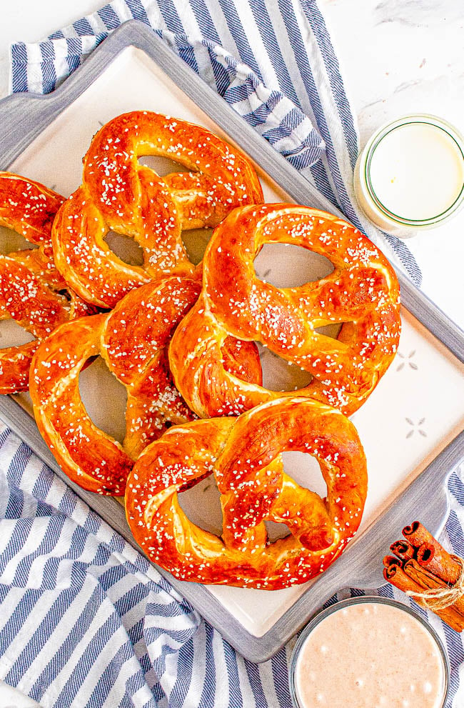 Homemade Soft Pretzels - These jumbo pretzels are soft, chewy, and just like the IRRESISTIBLE ones at your local mall's food court! Skip the mall and make these at home in ONE HOUR with this EASY to follow recipe and step-by-step photos! Whether you want to sprinkle them with coarse salt or cinnamon-sugar, these carby delights will be an automatic family FAVORITE! 