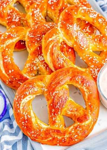 Homemade Soft Pretzels - These jumbo pretzels are soft, chewy, and just like the IRRESISTIBLE ones at your local mall's food court! Skip the mall and make these at home in ONE HOUR with this EASY to follow recipe and step-by-step photos! Whether you want to sprinkle them with coarse salt or cinnamon-sugar, these carby delights will be an automatic family FAVORITE! 