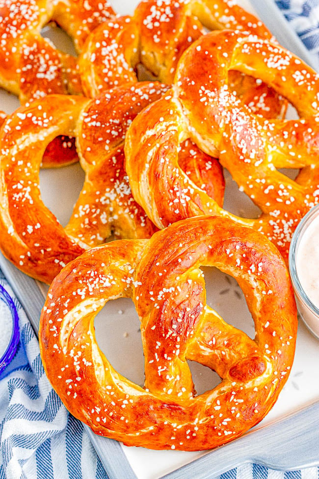 Homemade Soft Pretzels - These jumbo pretzels are soft, chewy, and just like the IRRESISTIBLE ones at your local mall's food court! Skip the mall and make these at home in ONE HOUR with this EASY to follow recipe and step-by-step photos! Whether you want to sprinkle them with coarse salt or cinnamon-sugar, these carby delights will be an automatic family FAVORITE! 