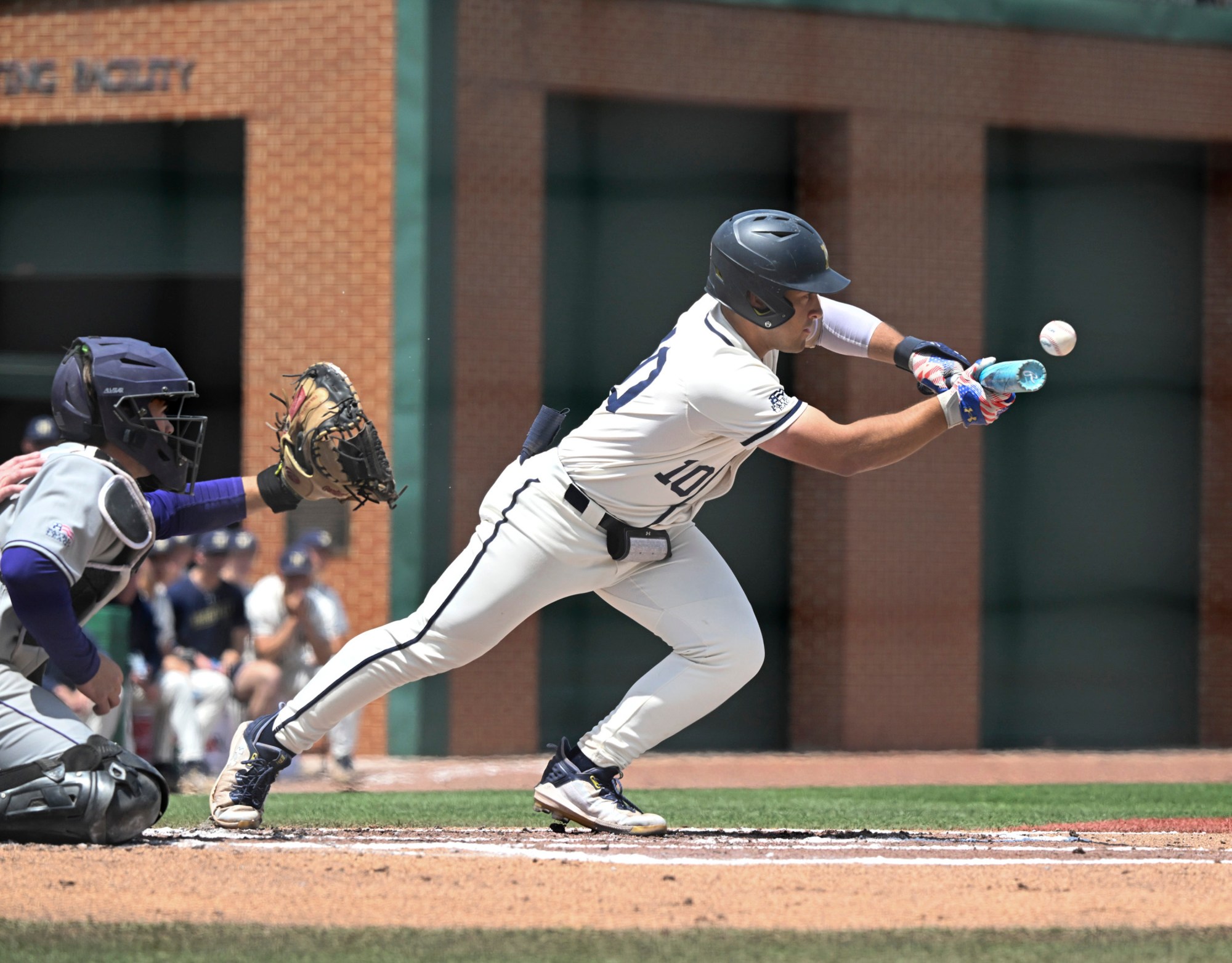 Navy shortstop Eduardo Diaz lays down a sacrifice bunt during Sunday's doubleheader against Holy Cross. (Debbie Latta/Navy Athletics)