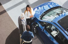 Car dealer talking with customers