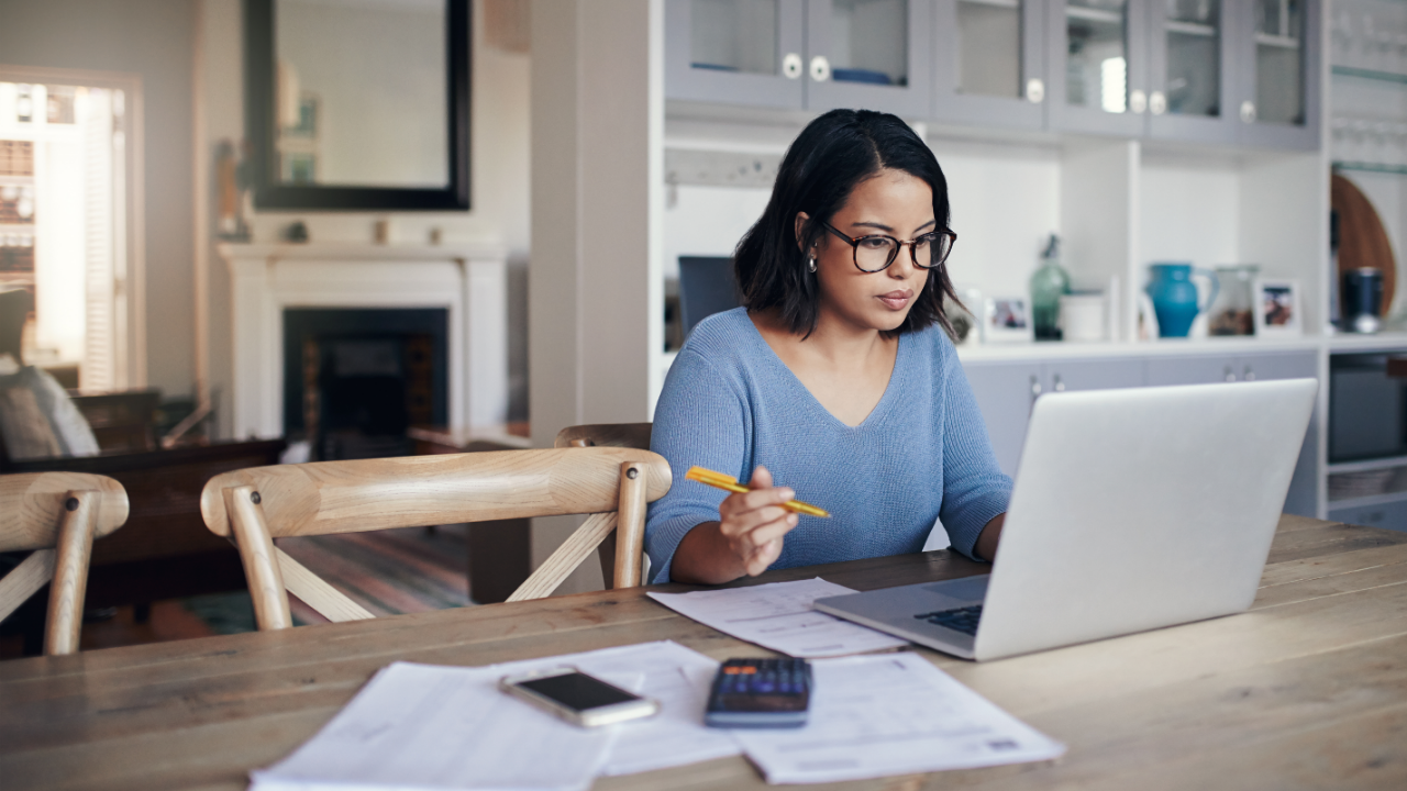 Woman reading financial documents at home