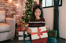 Young Asian woman opens Christmas gift box