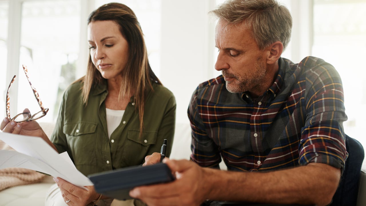 Shot of a mature couple managing their budget together at home