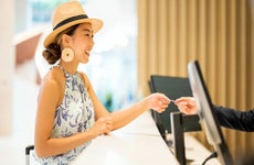 Woman paying for hotel room with credit card while on vacation.