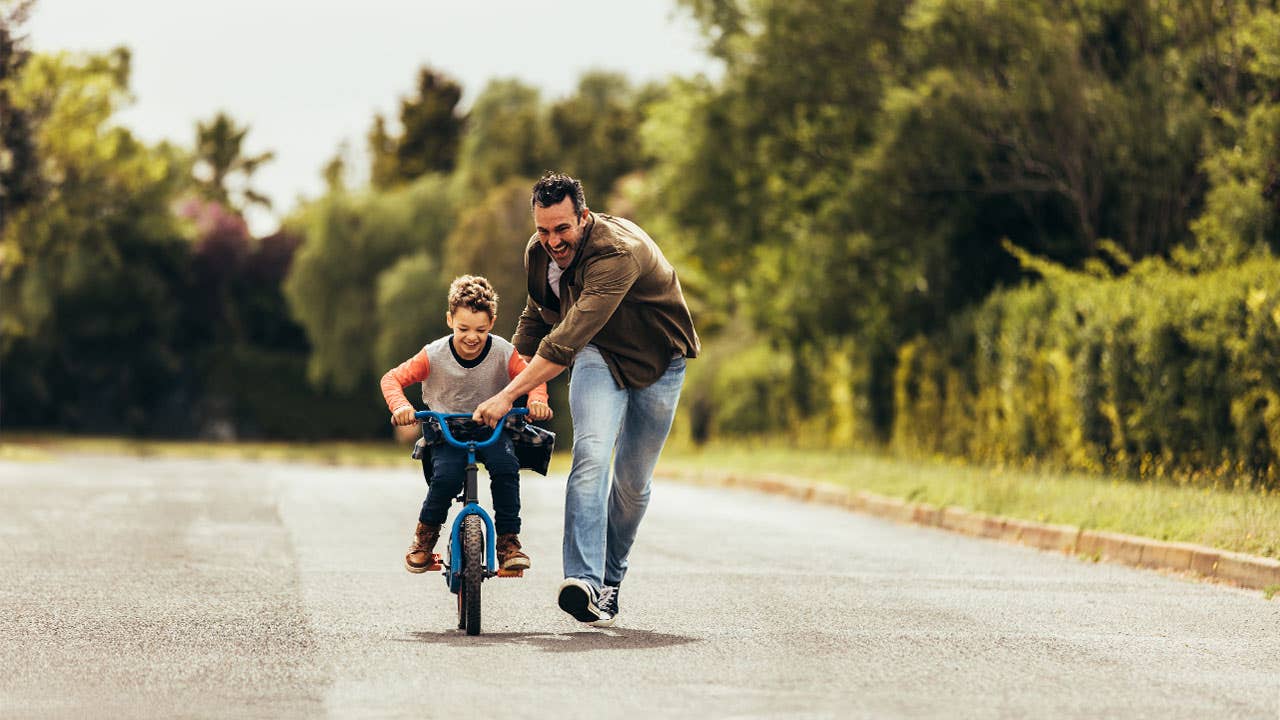 Father teaching son to ride a bicycle