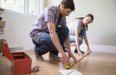 Couple measuring a hardwood floor