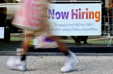 A "Now Hiring" sign is displayed on a shopfront