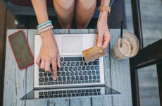 Person using computer and holding credit card