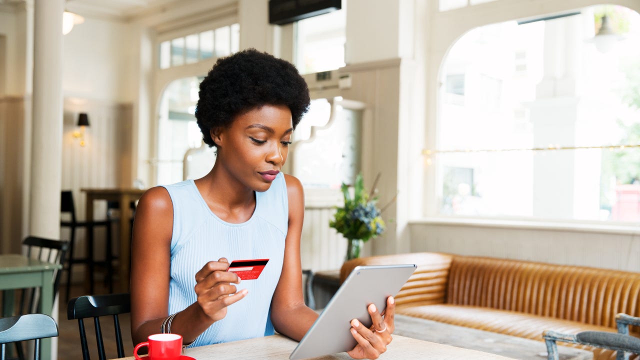 Person looking at tablet with credit card