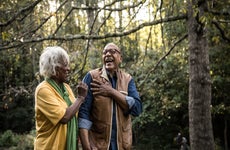 Two older homeowners take a walk in the park.