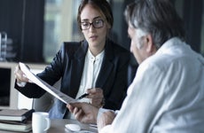 An older man sits down with a female financial advisor.