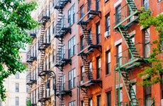 Apartment building facade with fire escapes.