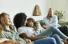 An interracial family laughing together in the living room