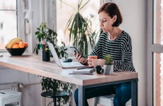 Woman working on laptop and smartphone