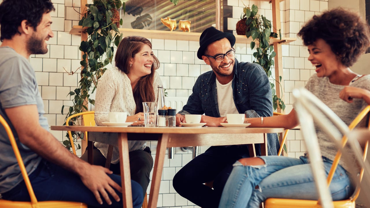 Group of young people around restaurant table